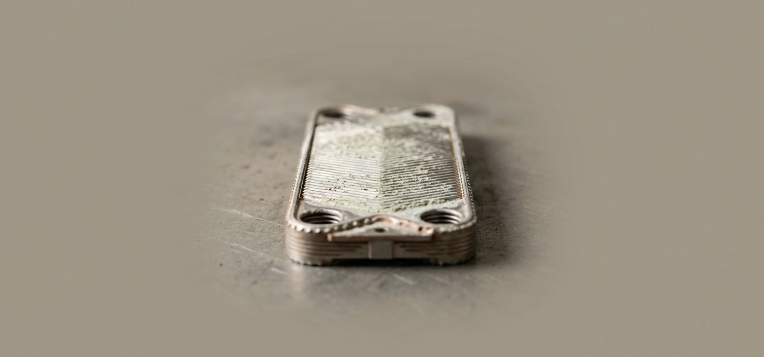 A brazed plate heat exchanger out of service, limescale across the plate faces